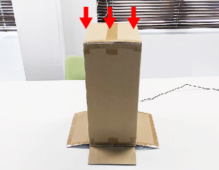 製品にビニールをかぶせ、さらに段ボールをかぶせている画像